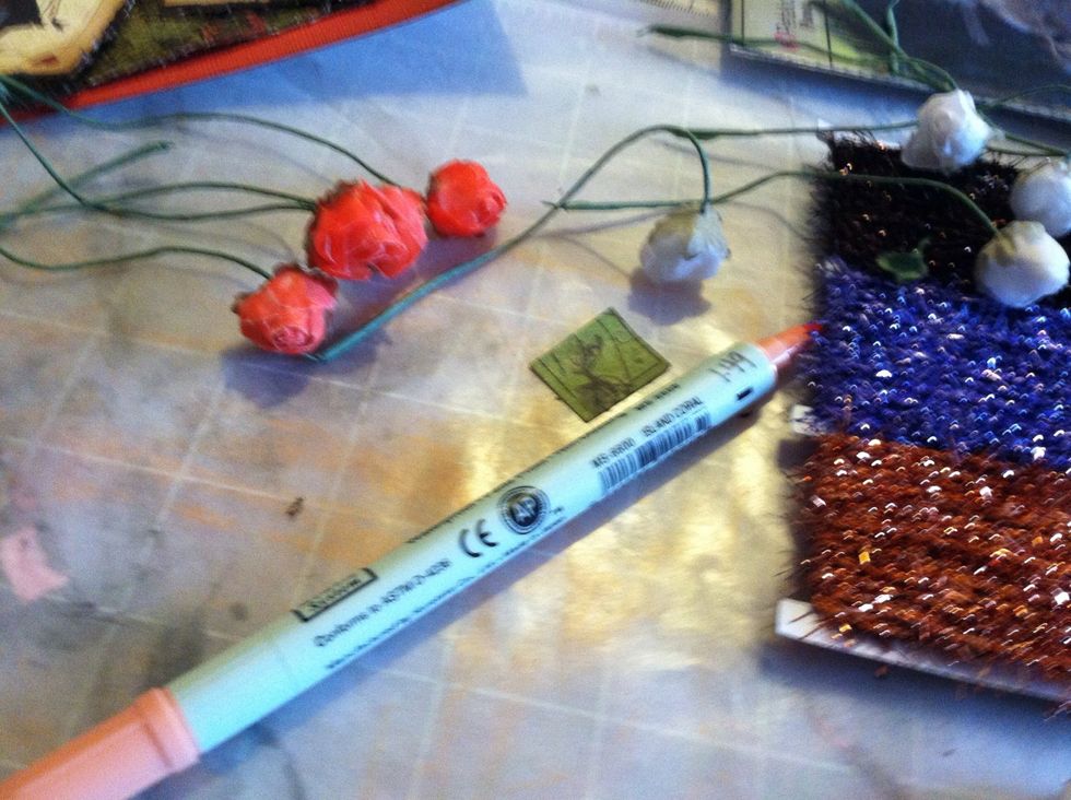 While choosing flowers to use I discovered there weren't enough that matched. I used my orange permanent marker to color white roses orange. (A trick I learned from Alice in Wonderland)