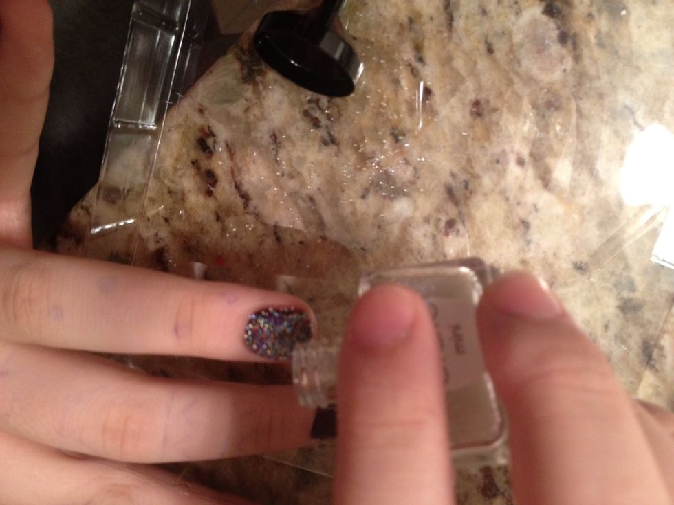 While nail is wet pour pearls over nail on tray