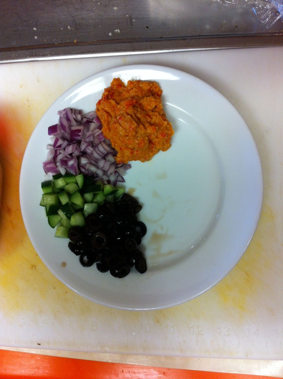 While Pita grills, on one half of CLEAN, DRY Plate, place equal wedge shaped portions of Olives, Cucumbers, Red Onions & Hummus. As pictured.