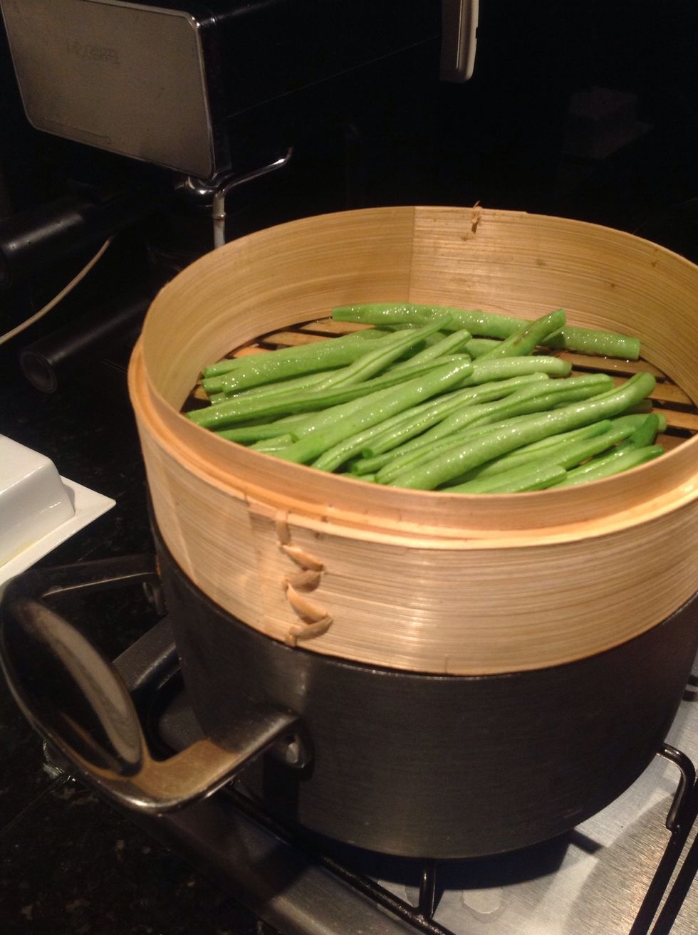 While potatoes are boiling, fill a bamboo steamer basket with green beans, cover them for 15 min and then you can saut\u00e9 them on a pan with butter