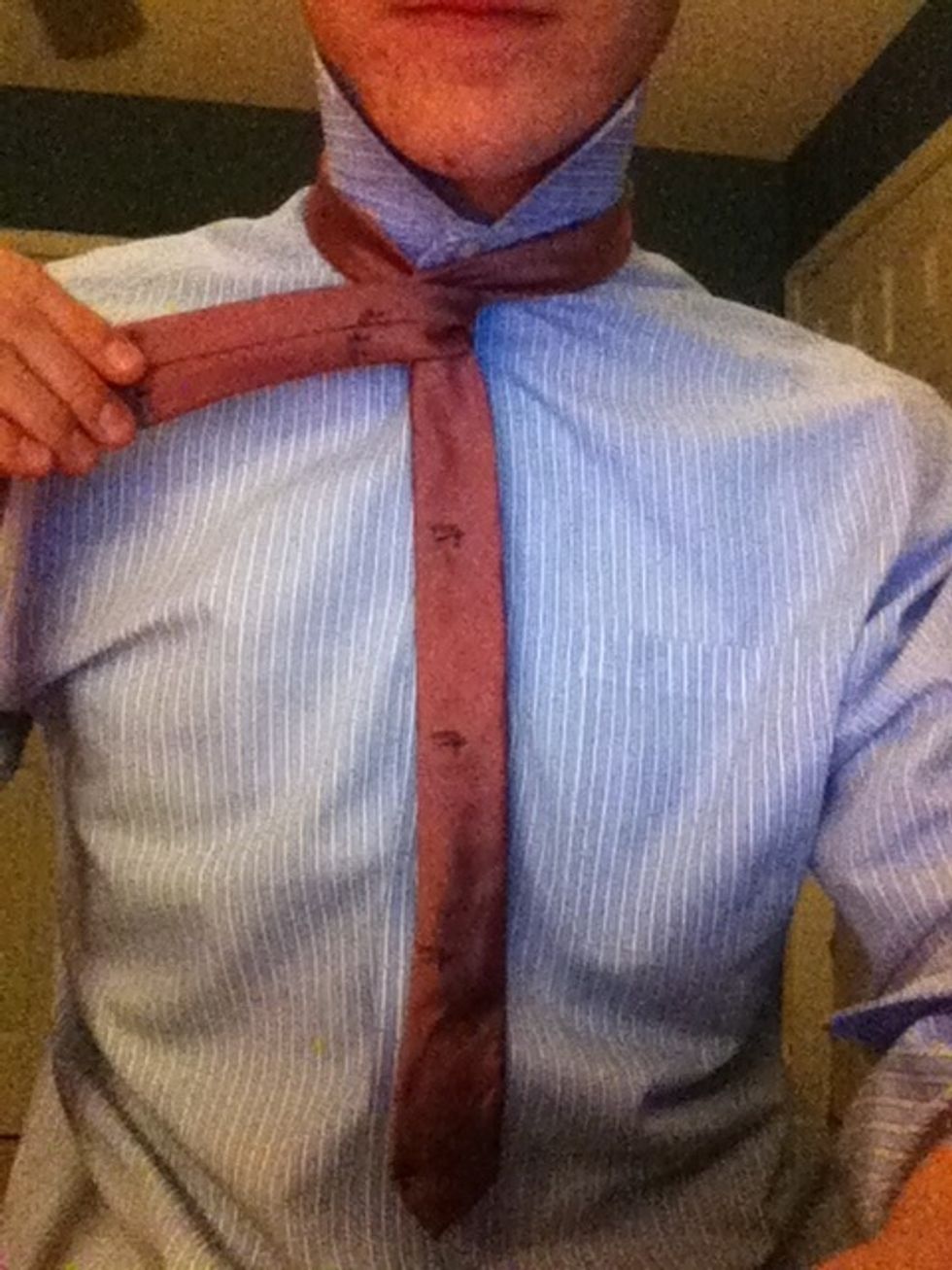 While still applying liberal pressure downward on the short, thin piece, pass the long, fat piece in front of it. The long piece should be on top.