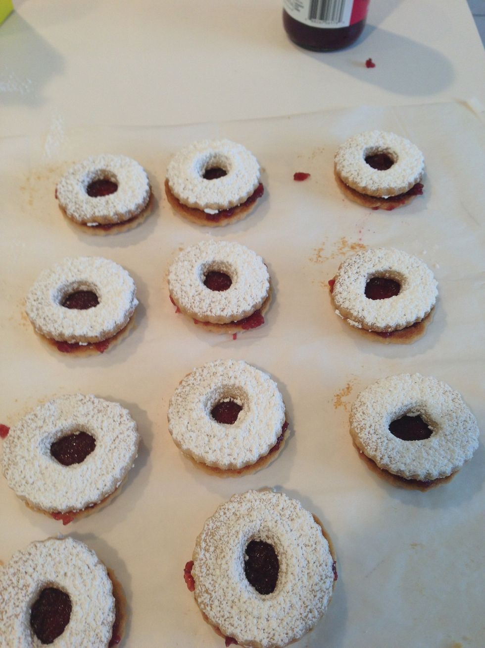 While still separated, using a sifter, coat the tops with powdered sugar BEFORE placing on top of the bottoms. Make a sandwich of the two cookies.