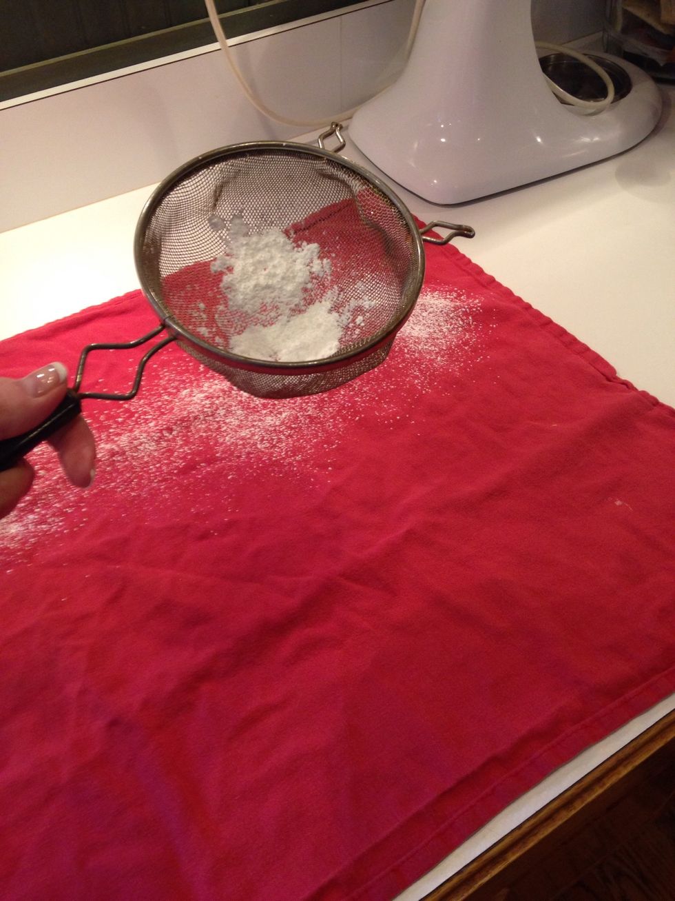 While that is baking, lightly dust a clean tea towel with powdered sugar. This will help keep the cake from sticking to the towel.