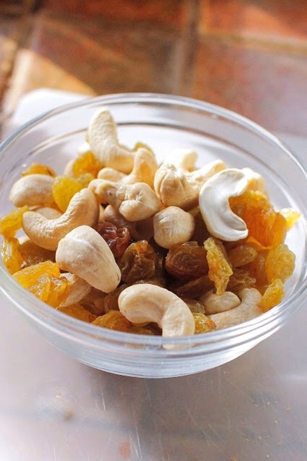 While the apples are cooking down add 1 Tbs oil to a small pan. When the oil is hot add in the cashews and raisins. Roast them until the raisins are plump and the cashews lightly toasted. Set aside.