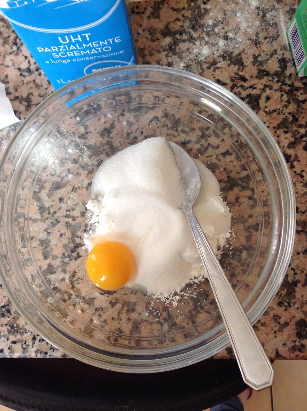 While the batter is resting, start preparing the milk cream. Put an egg, your sugar, a pinch of salt, two spoons of flour and your vanilla extract into a bowl.