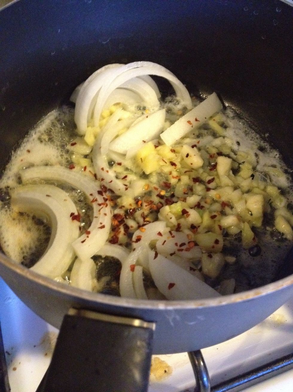 While the beans drain, heat olive oil and butter in a skillet. Add sliced onion, garlic, ginger, and chili peppers and saute for 2 minutes.