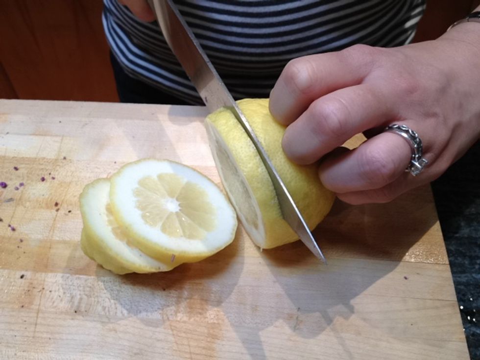 While the brine is coming to a boil, thickly slice a lemon.