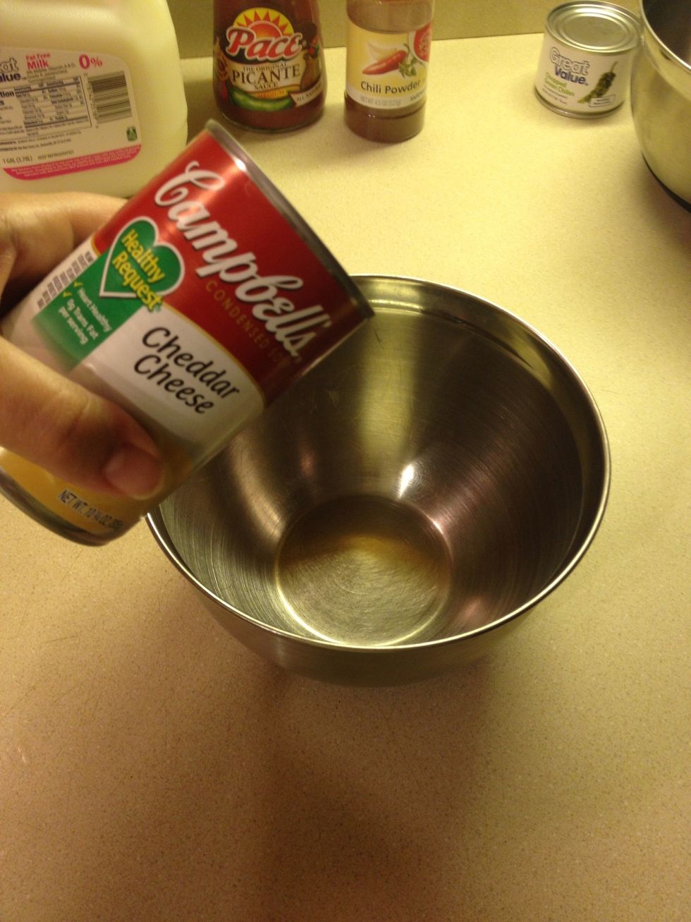 While the chicken is cooking lets make the sauce and prep the mixture. Put one can of Campbell's cheddar cheese soup into a small bowl.