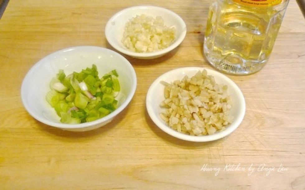 While the chicken is steaming in the wok, minced some ginger and garlic. Also chopped some green onions and have ready the vegetable oil.