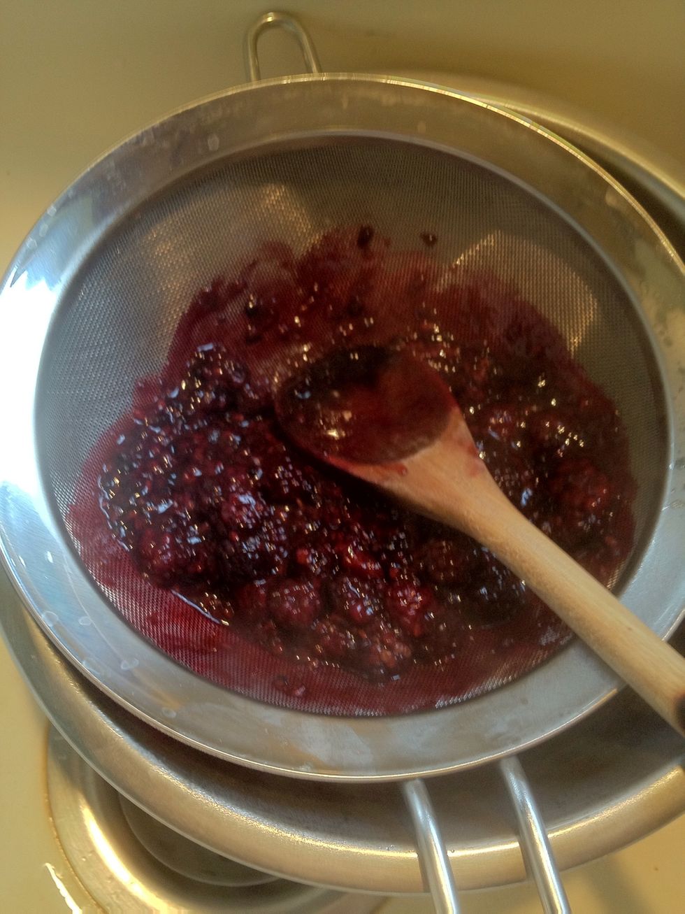 While the chocolate is melting, strain the blackberry sauce to remove seeds.