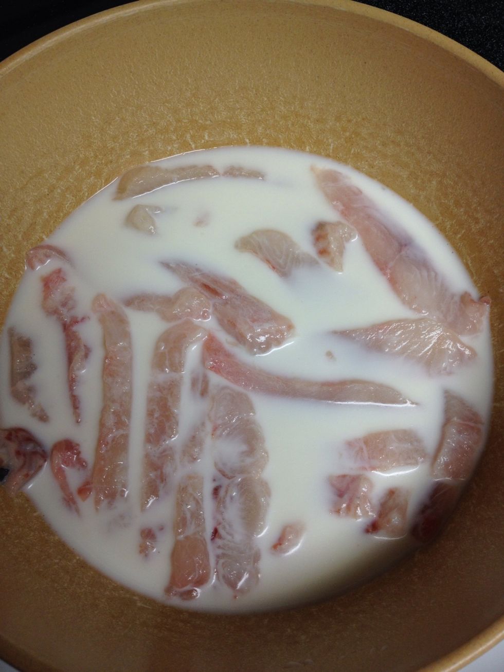 While the oil is heating up whisk in an egg into the fish and milk.