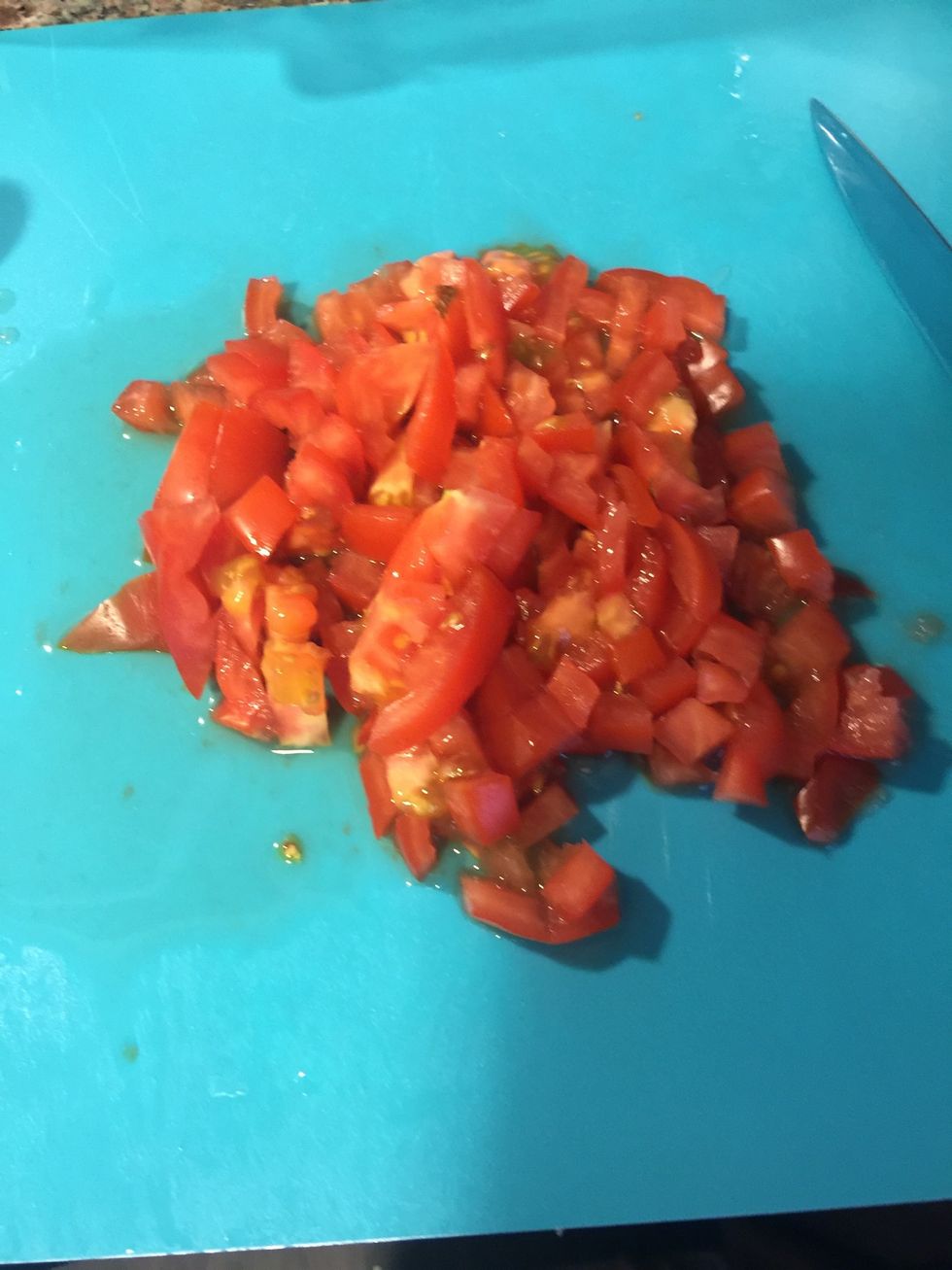 While the onions are cooking, chop one tomato.