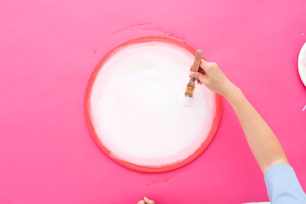 While the orange/pink paint is still wet, paint the pink/white paint under the orange/pink. Blend the two colors together so there is a slight ombre effect. Paint the middle of the circle white