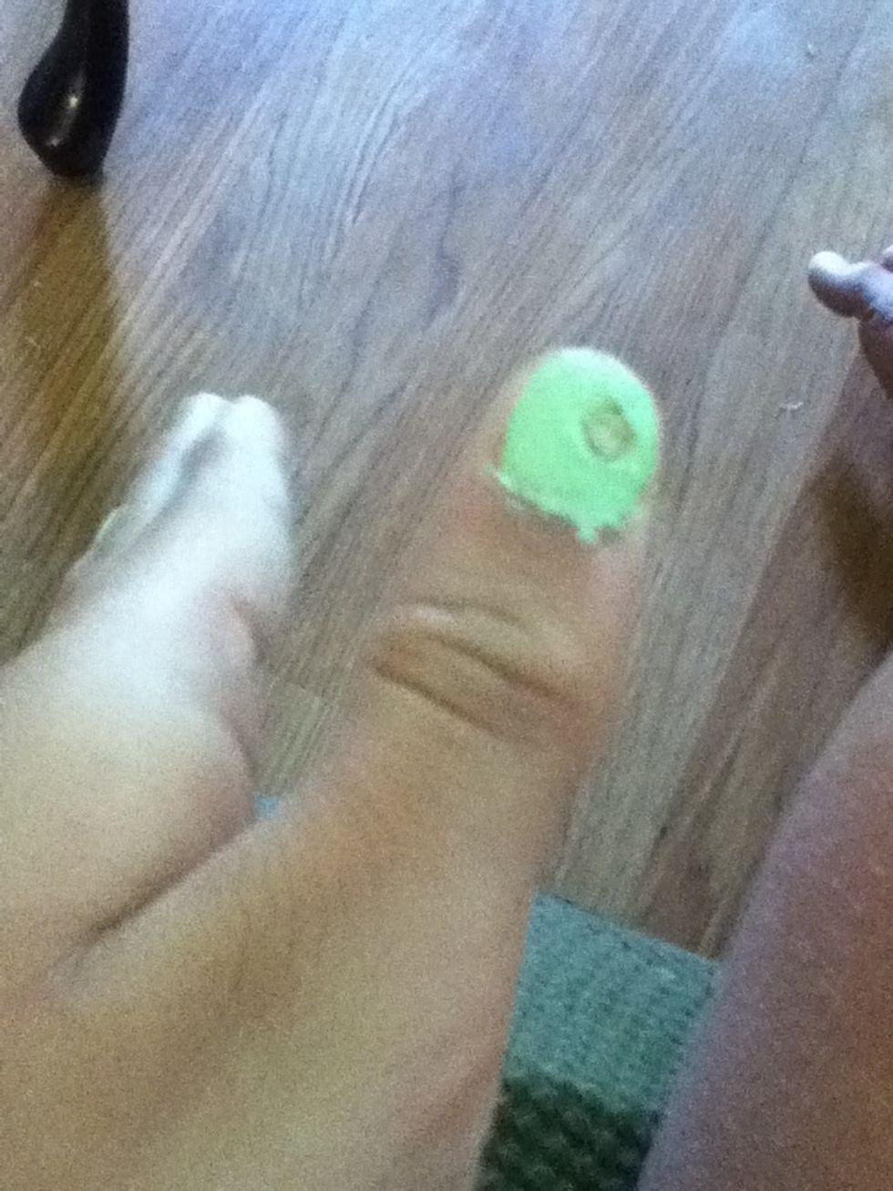 While the polish is still tacky make a small hole with the toothpick in the polish.
