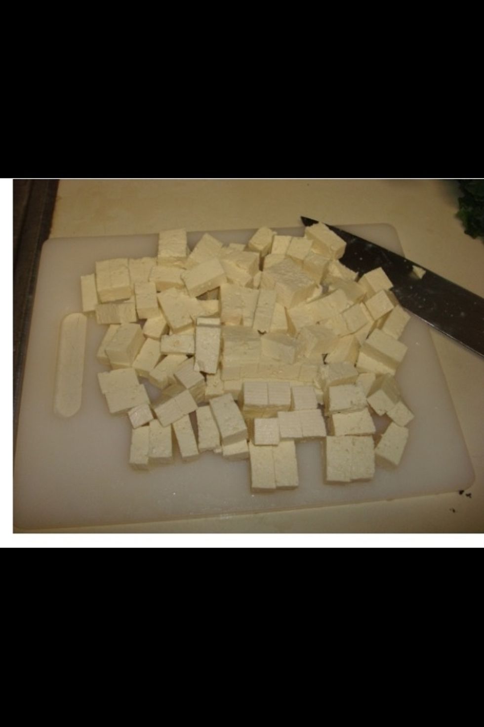 While the rice cooks, prepare the other ingredients.  Start by removing the tofu from the package, draining, rinsing and cubing.