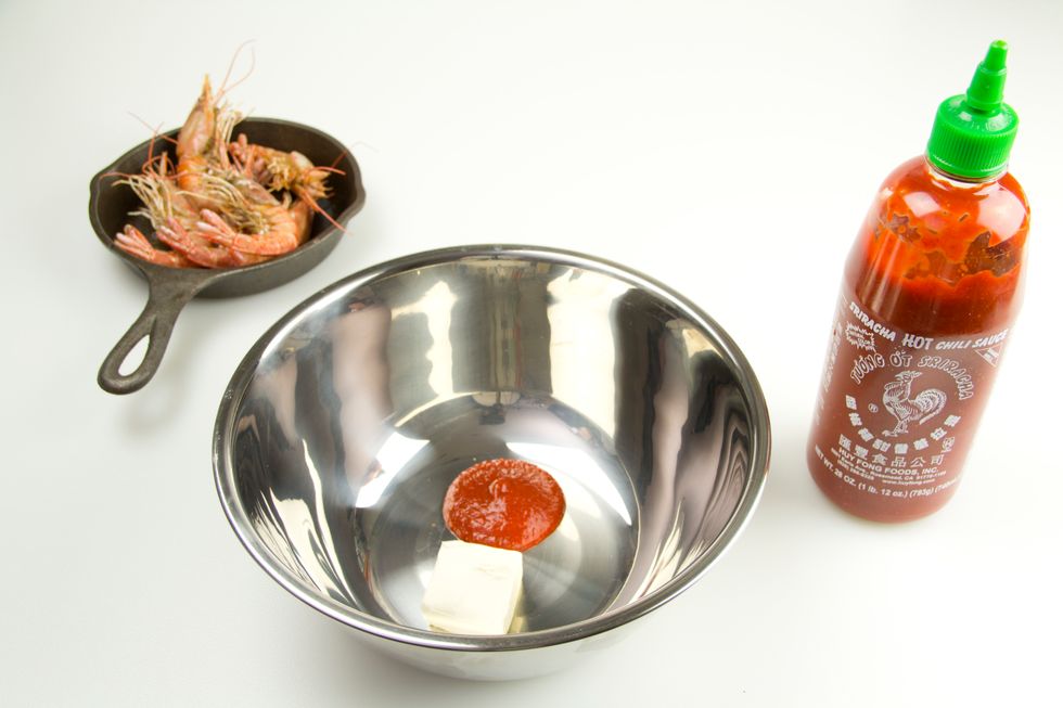 While the shrimp are cooking, place butter and sriracha in a mixing bowl, large enough to be able to toss everything together. The butter will help temper the spiciness of the hot sauce.