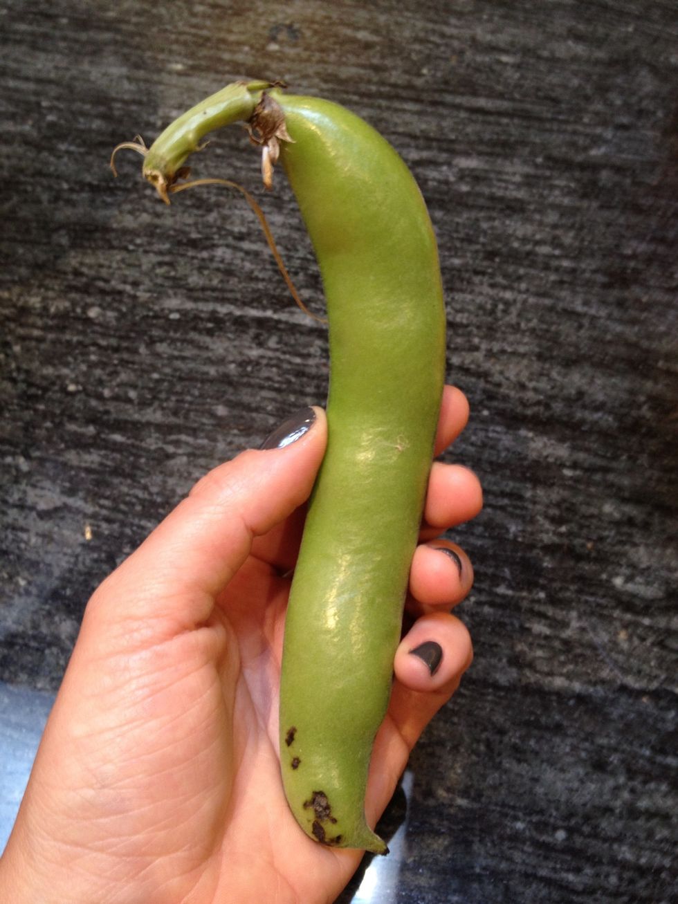 While the soup is simmering, you can prepare the green beans and favas. These will be cooked separately to retain their bright green color. Start by shelling the fava beans.