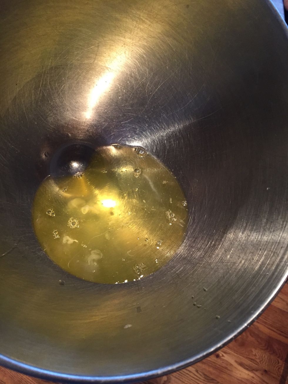 While the syrup is boiling, add 4 egg whites to a mixing bowl. Add a pinch of salt and cream of tarter