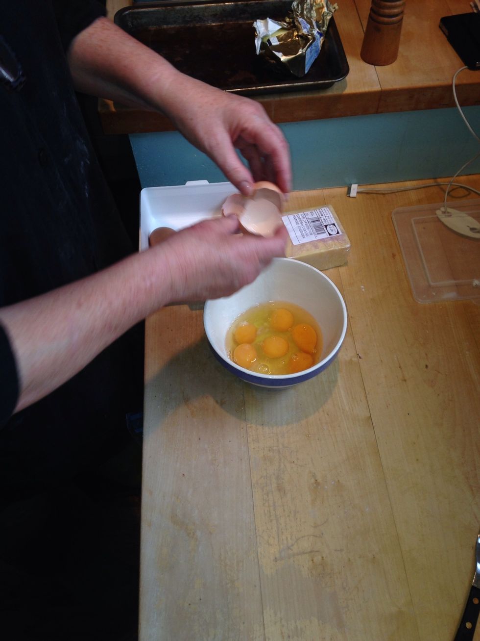 While the tray is in the oven, break 8 large eggs into a bowl