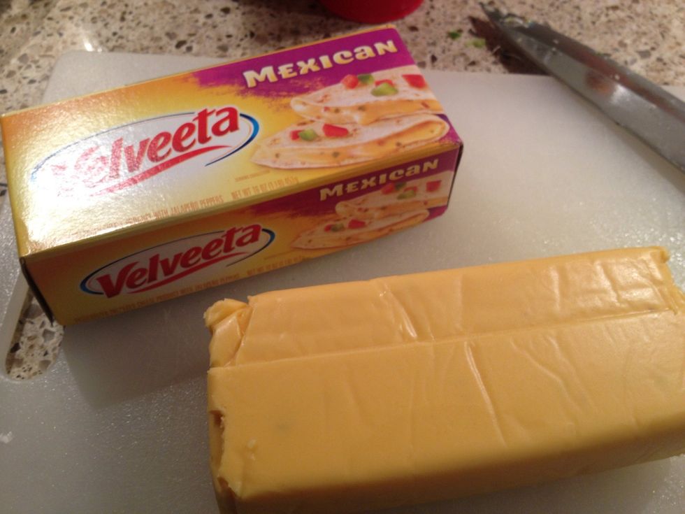 While the vegetables saut\u00e9, dice up 8 oz Mexican Velveeta or, if that isn't available, another peppered cheese. (Ex: jalape\u00f1o cheese roll or pepper jack)