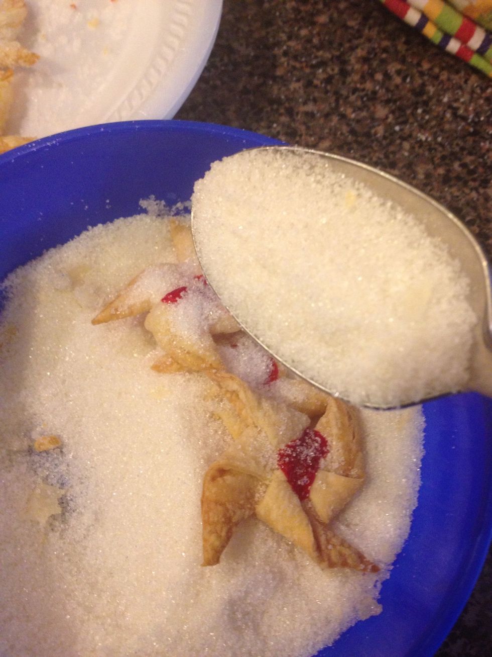 While they're still hot, cover them in white sugar on both sides.