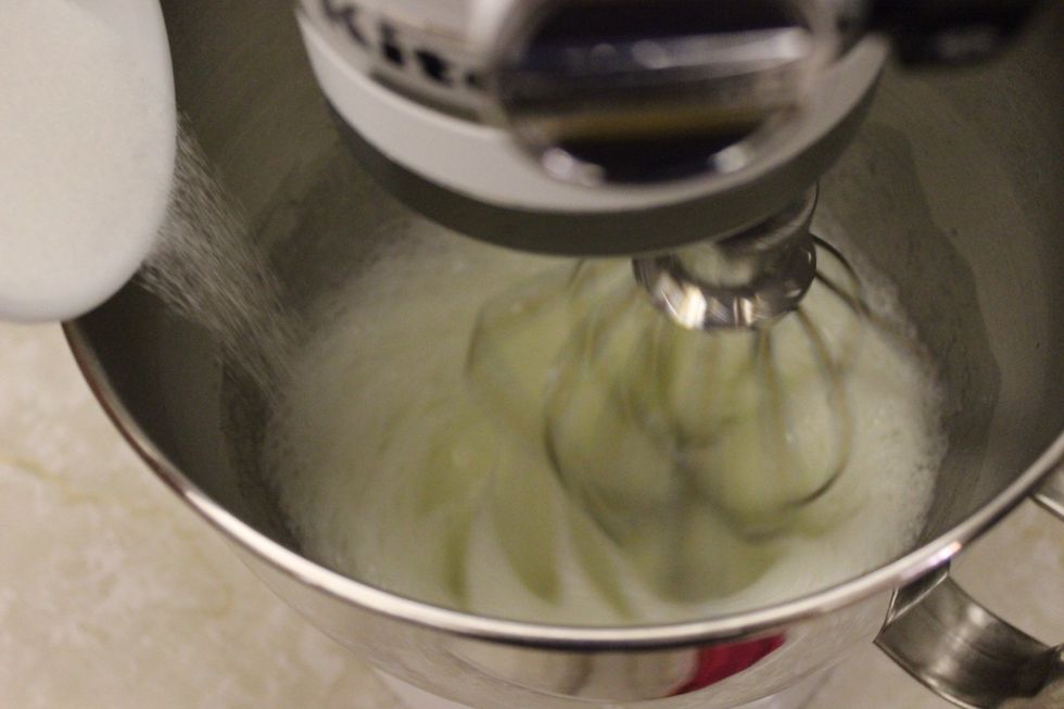 While whipping, slowly add the first half of the granulated sugar.