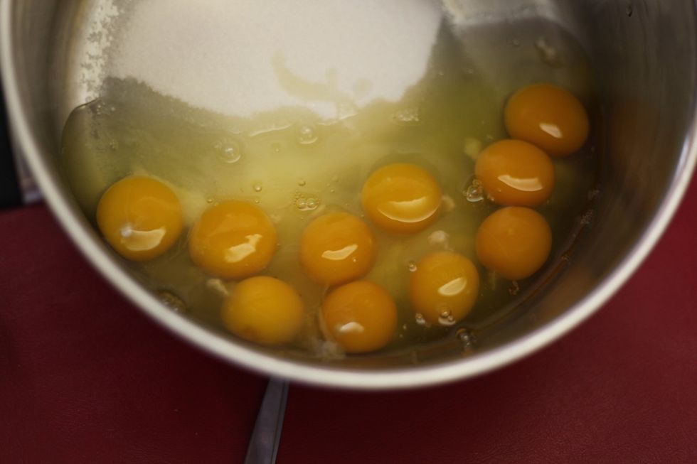 While you're adding the 10 eggs, start your stove on a medium heat and whisk around and around until you get a fine scramble of sugar and egg.