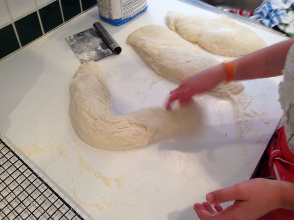 While you're slapping, turn the dough over to look for excess flour. Shake the dough to get it off. You don't want those wrinkles to be full of flour and you can shape the loaves right on the paper