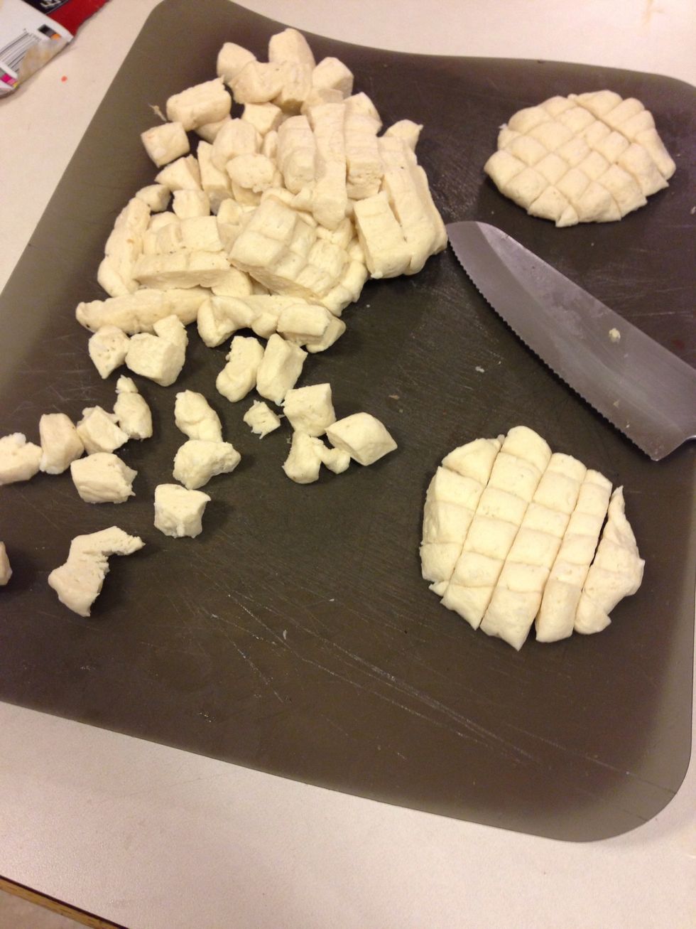 While you're waiting on it to boil open our biscuits and cut them up like so