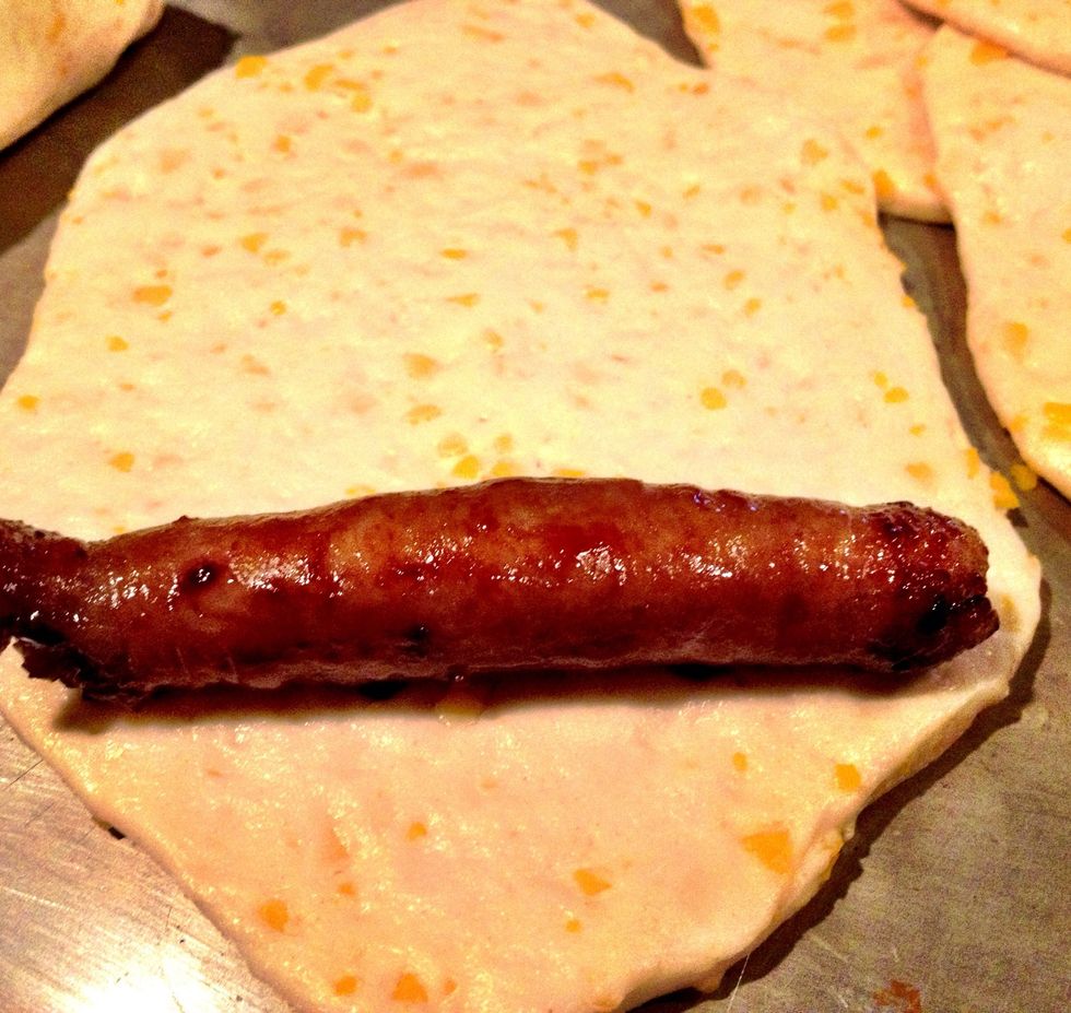 While your gravy is simmering, place one sausage on each flattened biscuit. Here's the fun part: sausages are usually 14 in a pack; biscuits, 8 in a tin. So freeze half your sausage, or buy two tins.