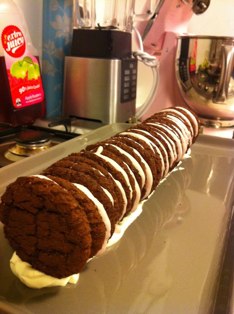 Whip cream until firm peak stage. Put a small amount on one side of a biscuit and sandwich together, repeat until desired length is achieved.