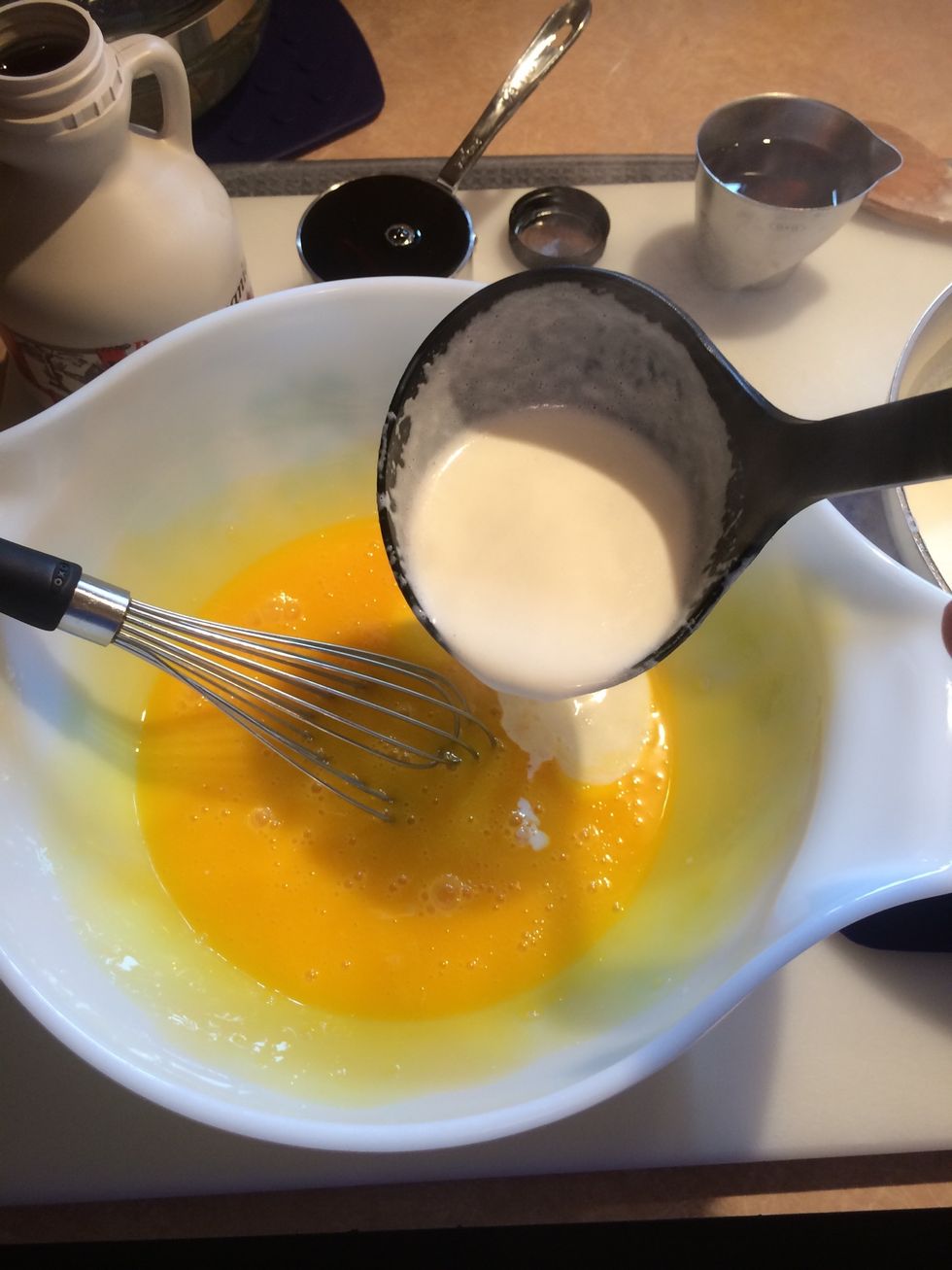 Whisk eggs constantly while slowly ladling in the hot cream.