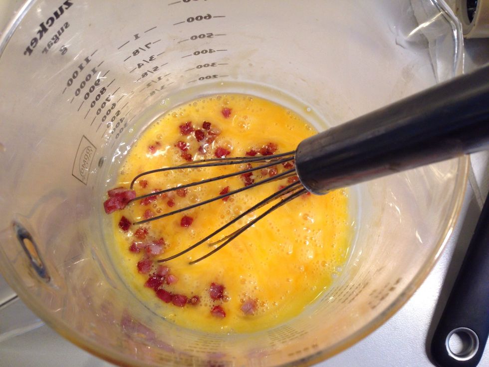 Whisk the eggs and add the fried diced bacon. Add a pinch of pepper and a bit of salt. Keep in mind that the diced bacon is already salty.