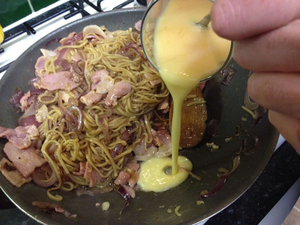 Whisk your eggs in a cup or small bowl. Now this is the fun part, turn the heat down to medium and add the whisked eggs to the bottom of the wok.