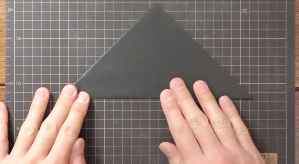 White side up, fold in half diagonally.