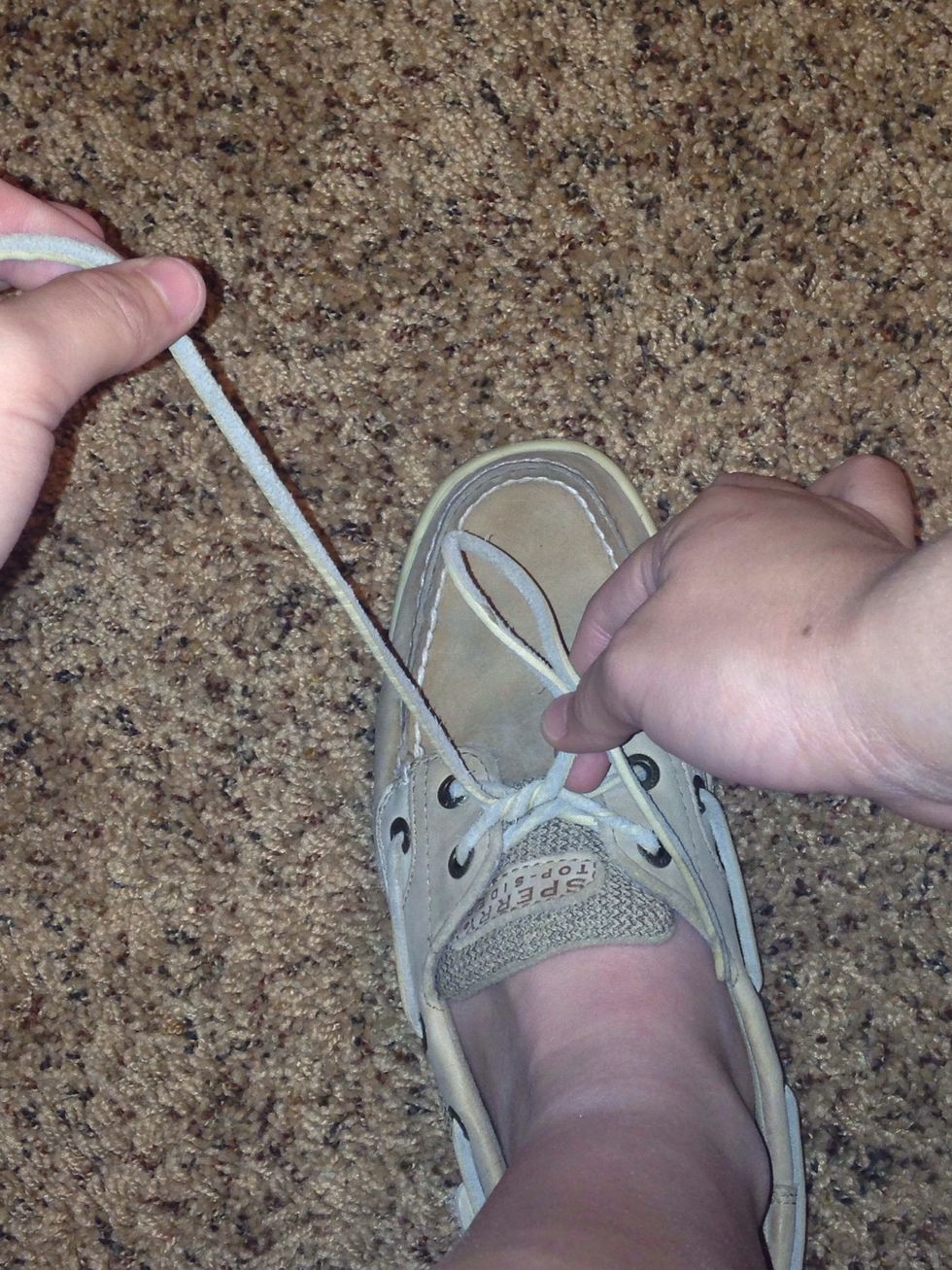 With 1 of the laces, make a loop. Make sure you are holding firmly.