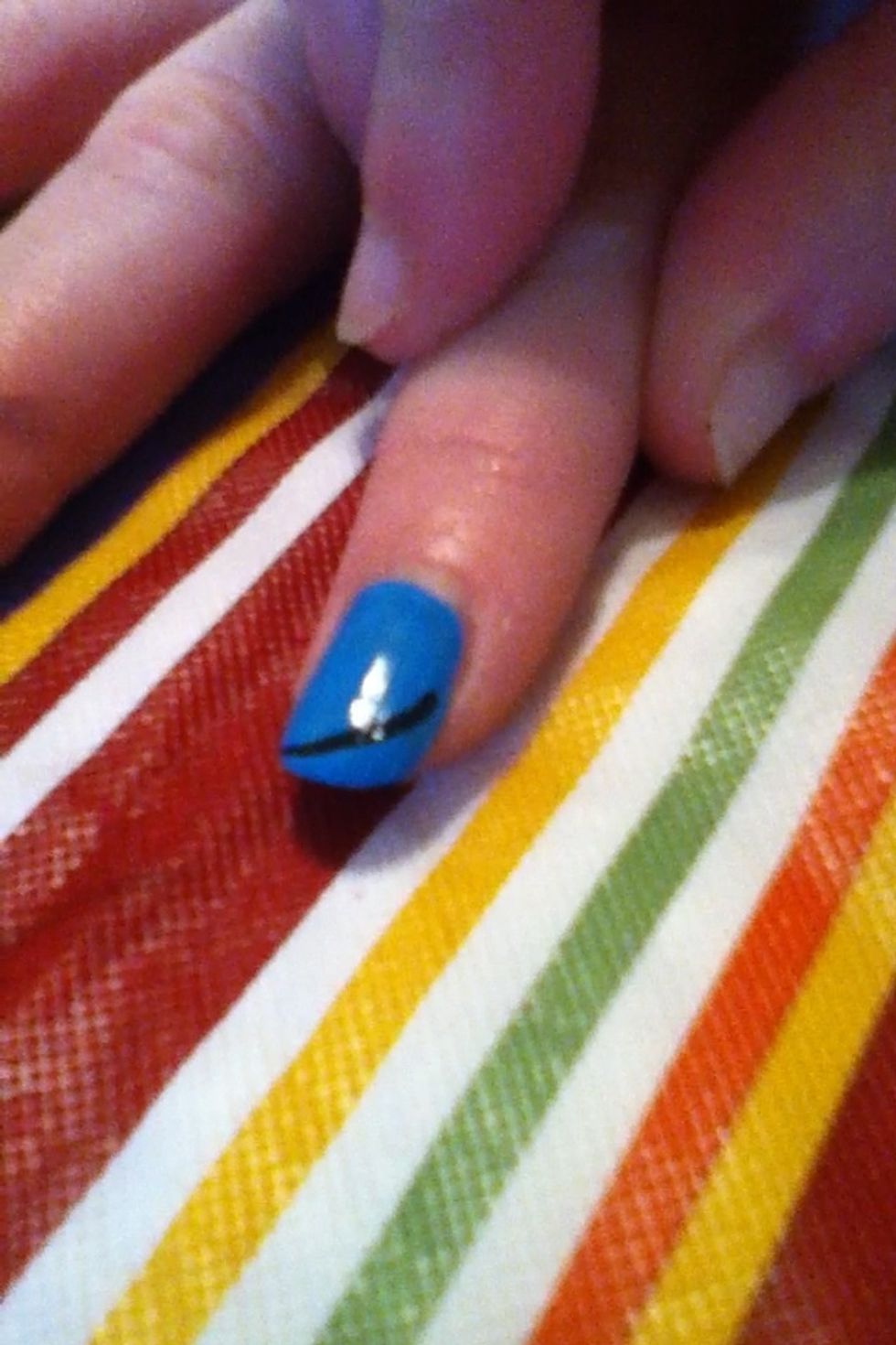 With a black nail polish start from the middle of the nail and creat a dipped curve going to the corner of the opposite side.