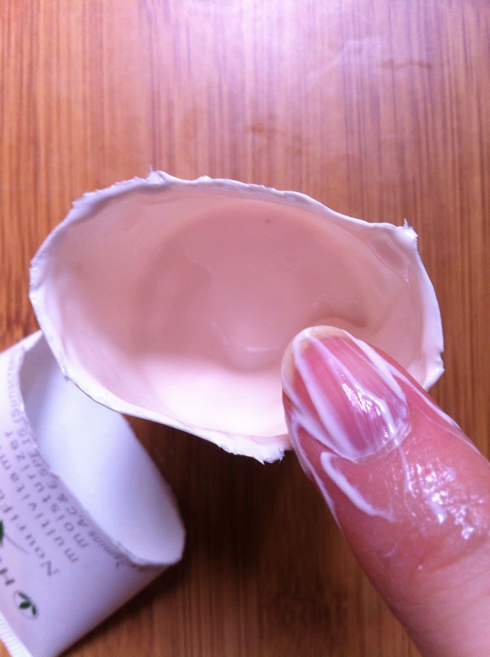 With a clean finger, scrape the remaining product from the top part down into the bottom part. This will prevent you from making a mess, smearing the cream all over when you put the parts together.