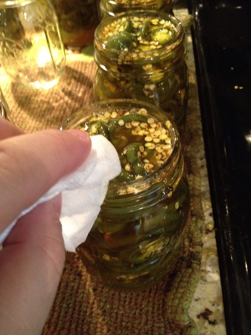 With a damp paper towel, wipe the rim of the jars.