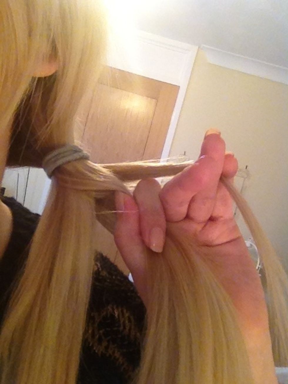 With a firm grip take a little from the far outer side of that section and cross this back over to the other section