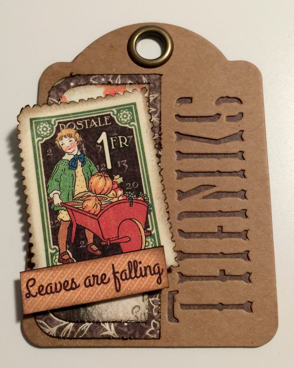 With a fourth brown thanks tag, foam square a stamp on an angle overtop of brown floral piece. Roll the top left corner down. To finish, adhere "Leaves are" to the bottom left of the stamp.