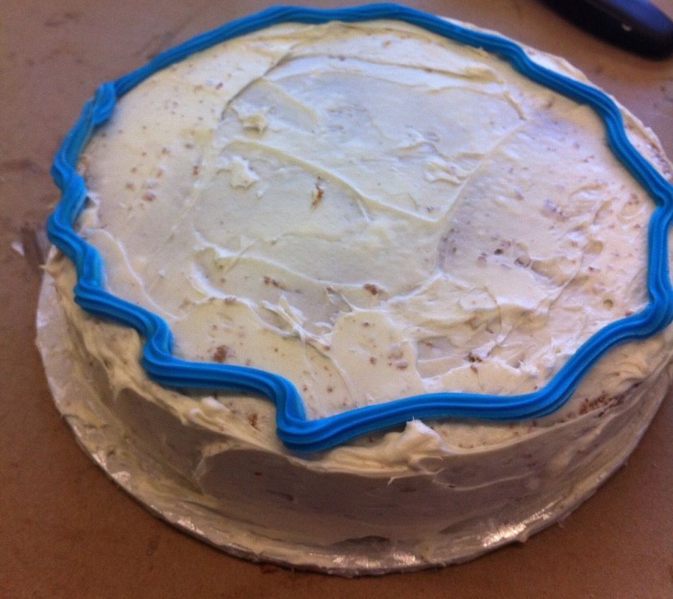 With a icing bag and a # 12 star tip swirl around the perimeter of your cake. ( you can use colour gel to colour icing if you wish)