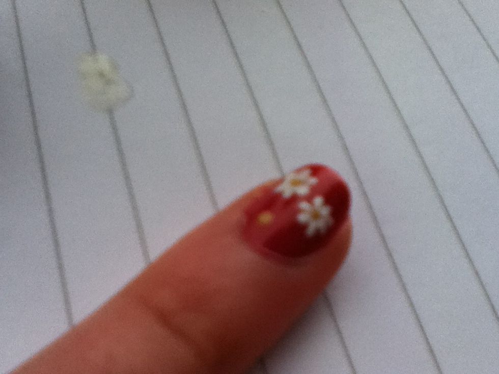 With a pencil dab around the yellow dots to form petals.