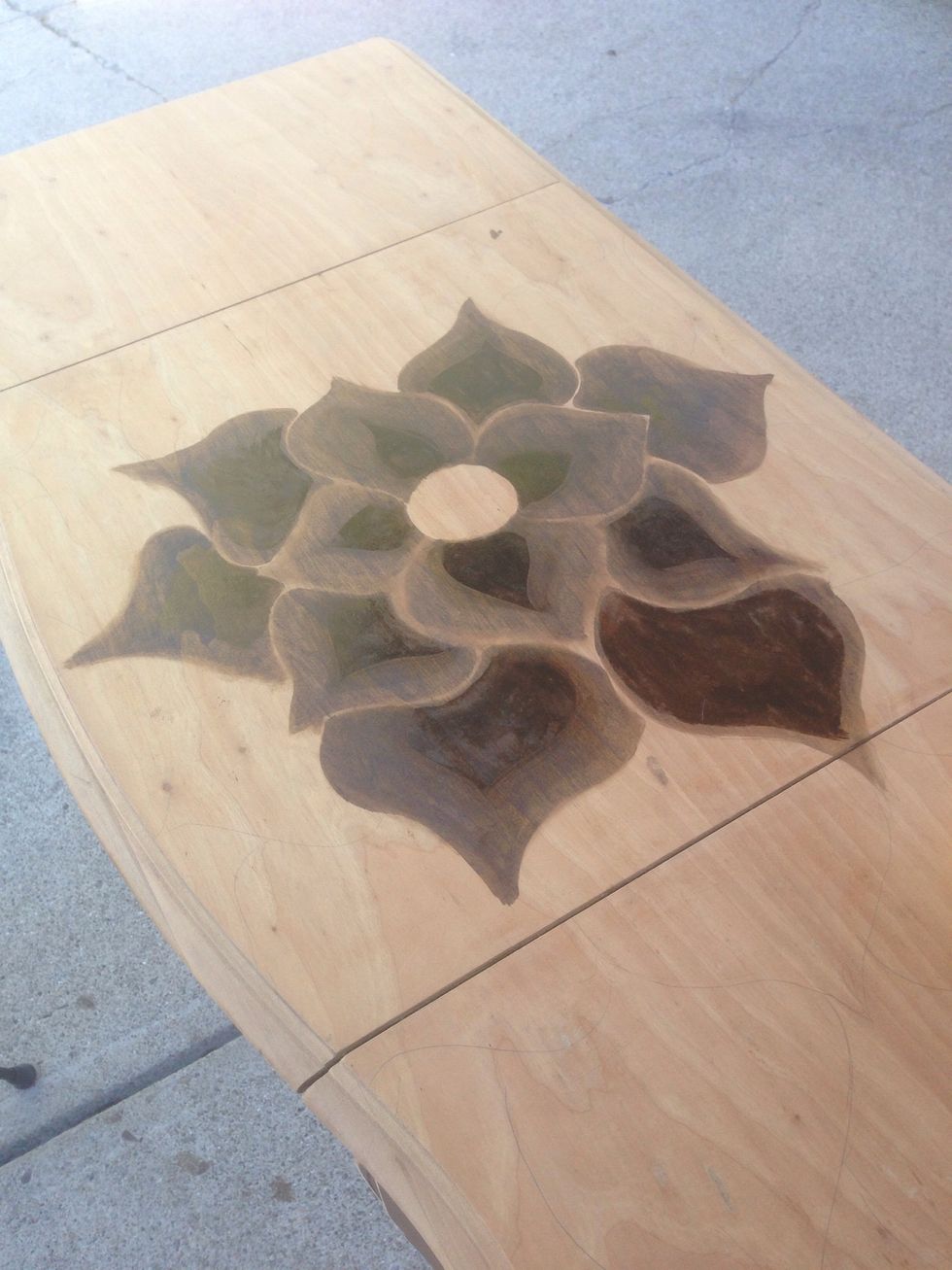With a pencil lightly draw your pattern.   With the t-shirt around your finger, dip into stain and trace the outline of the petal and fill in to center. Using the brush apply more stain to the center