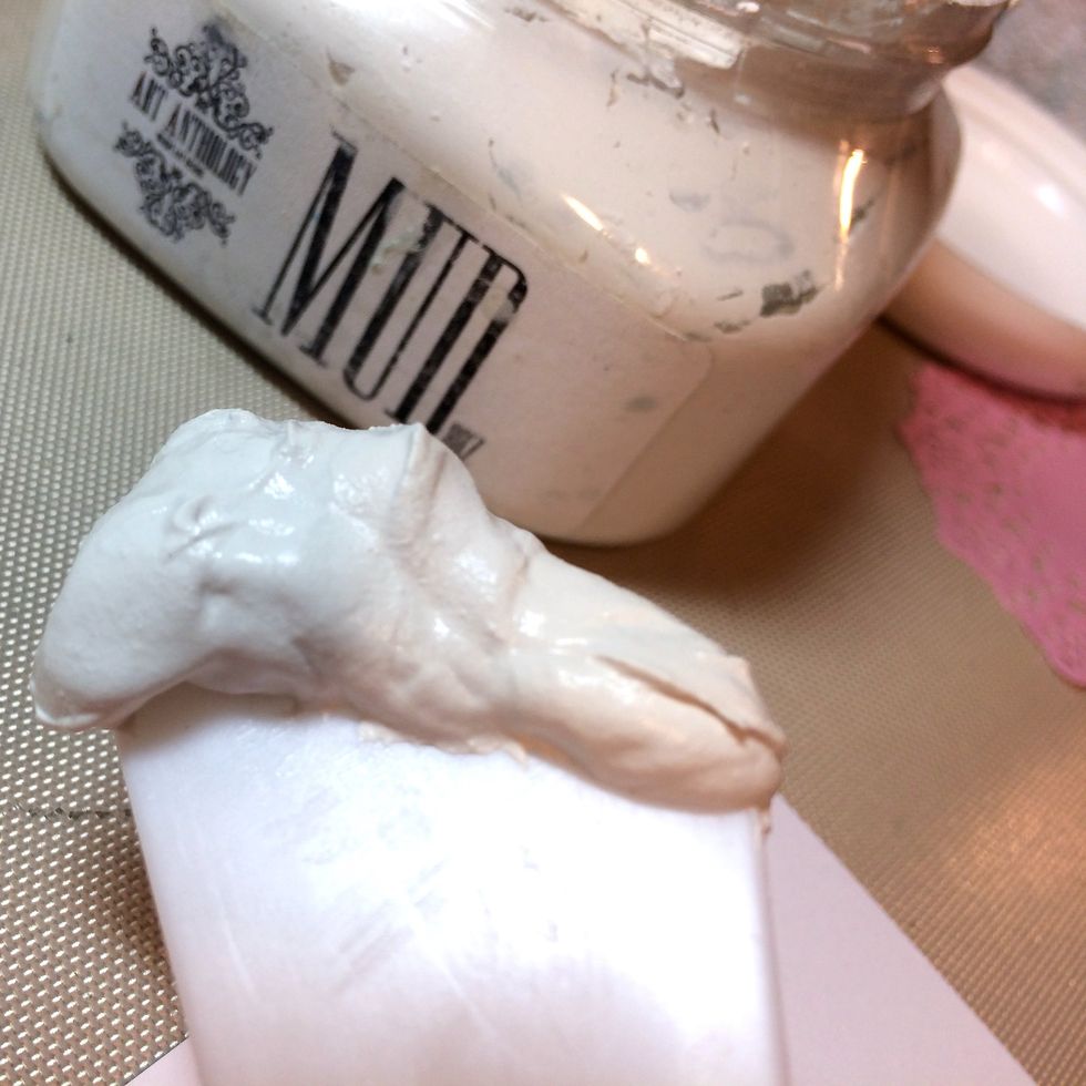 With a spatula, I get a dollop of Mud Texture Medium.