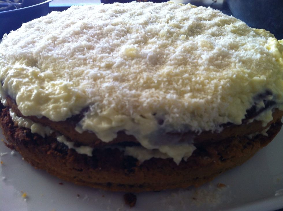 With a spatula spread the cream cheese frosting and sprinkle the leftover 1/4 cup dessicated coconut on top. Serve with a dollop of vanilla or coconut ice cream. BON APPETIT.