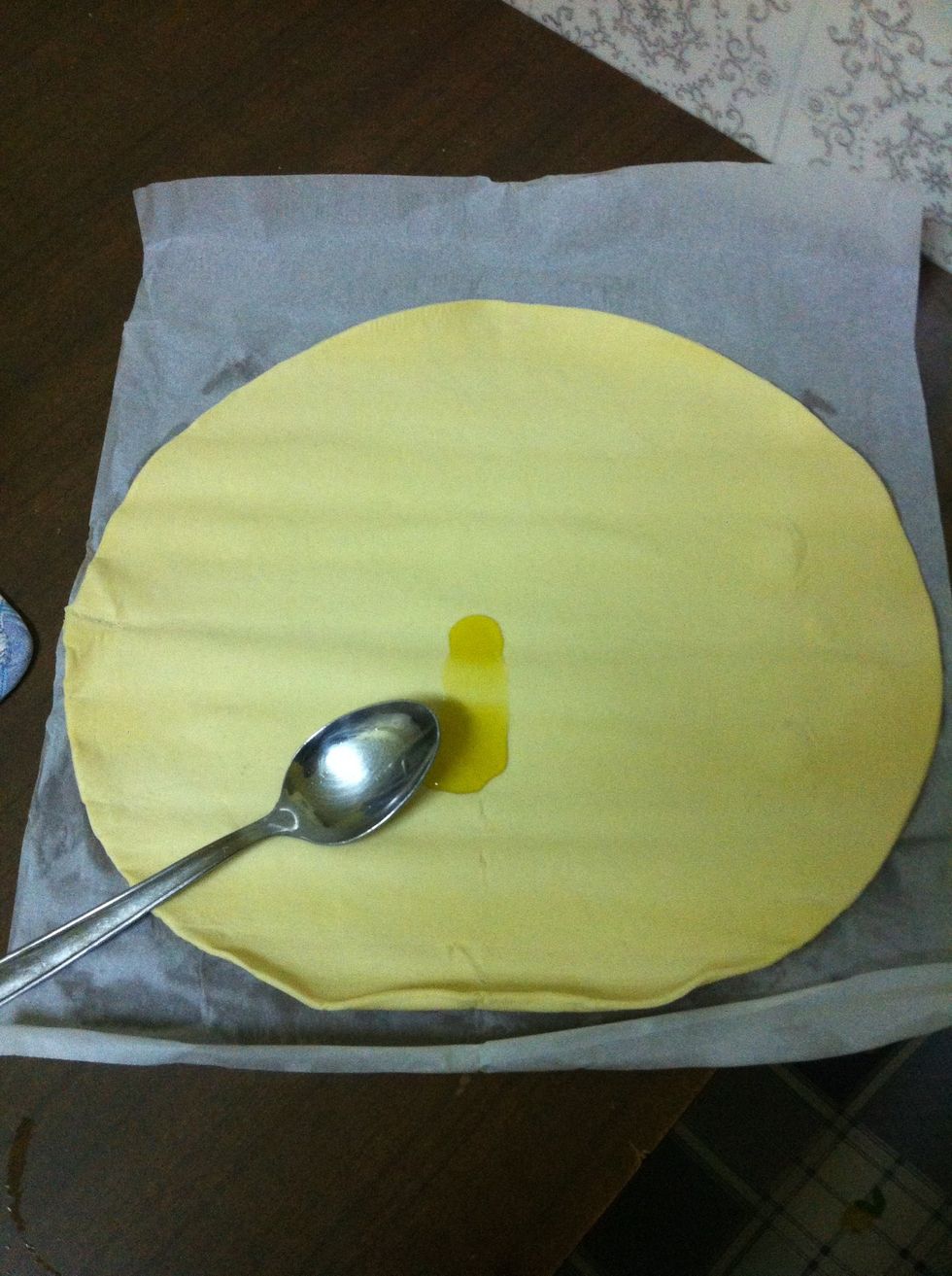 With a spoon cover the focaccia with some oil and parmisan