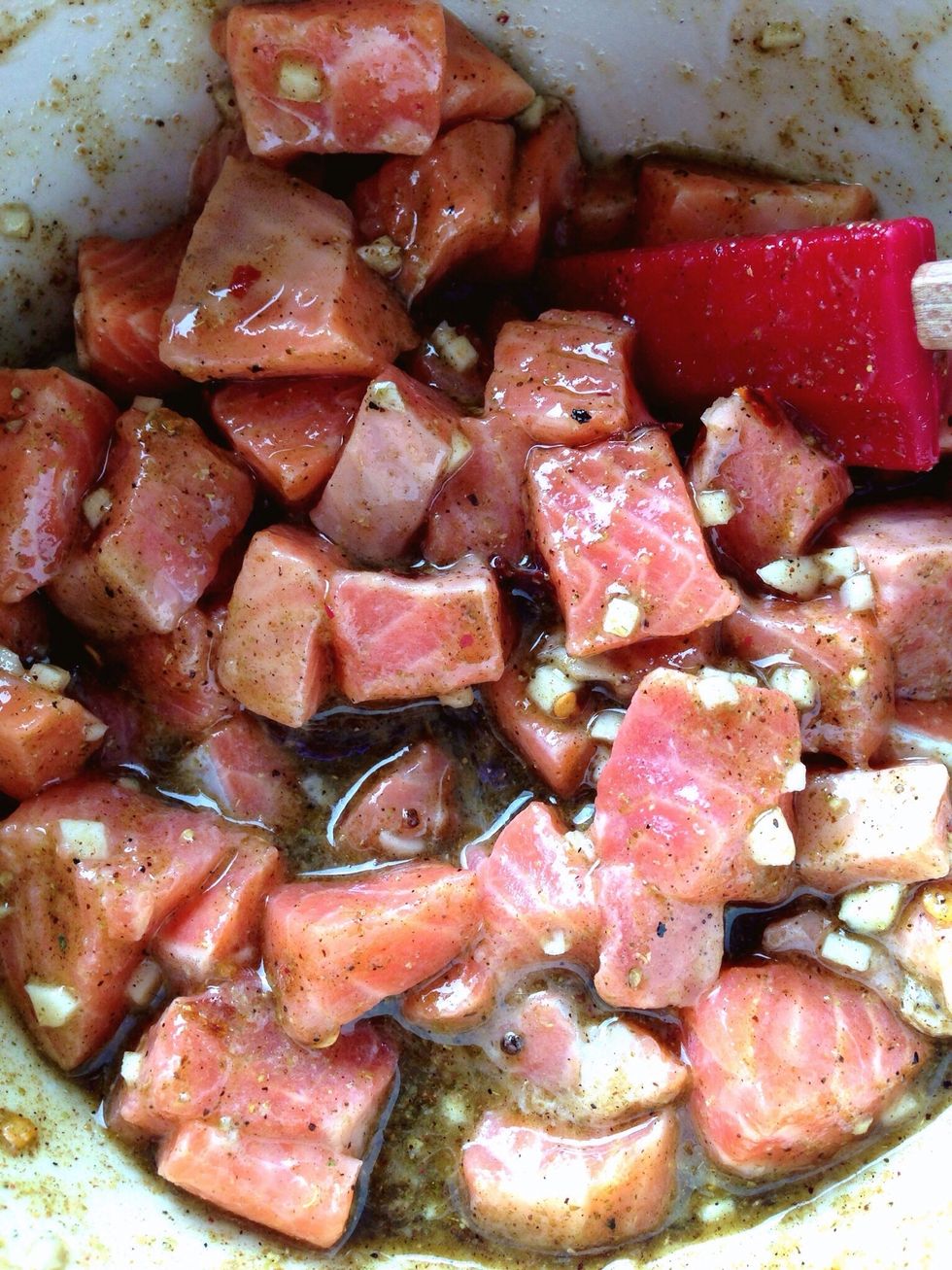 With a spoon or spatula, add in the fish and mix until everything is evenly coated.