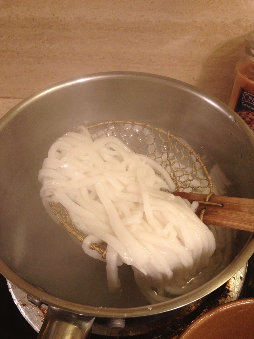 With a strainer or slotted spoon, pull the noodles out and place in a soup bowl. After about a min, the water will come back to boil so add the wonton noodles and repeat same steps as with rice noodle