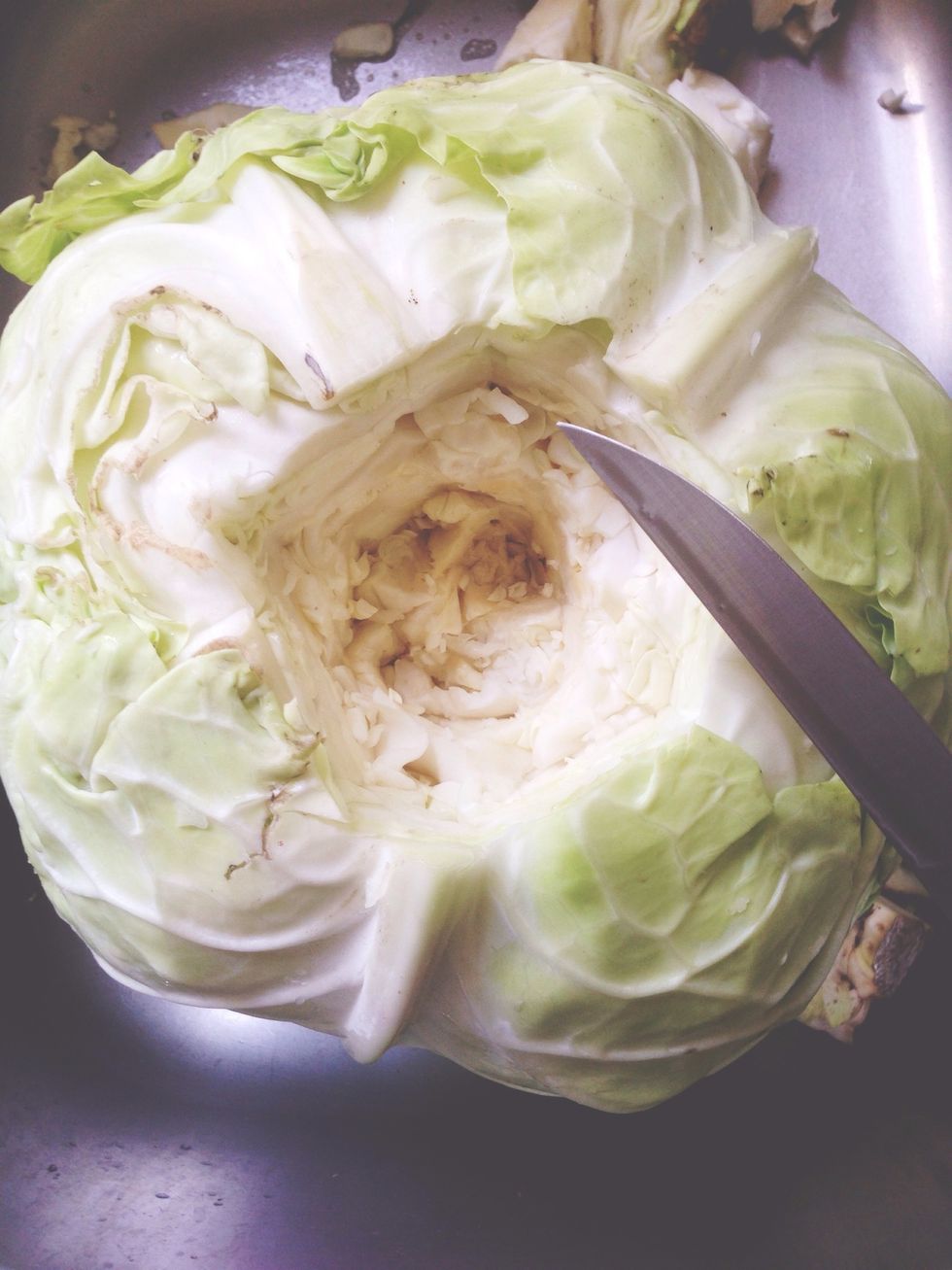 With a strong knife, cut out the core of the cabbage. Be very careful not to cut yourself or break the blade.